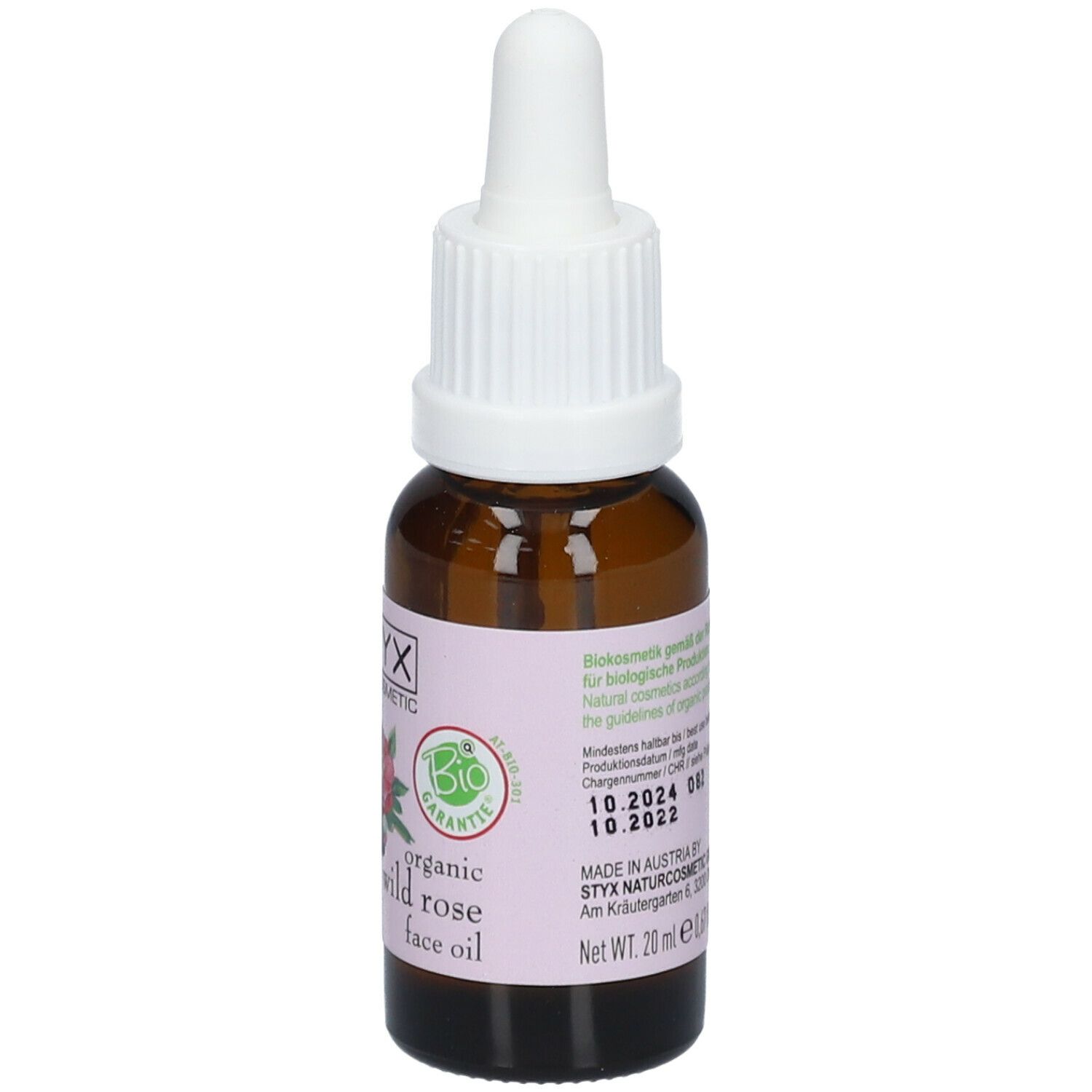 Flacone di vetro marrone con contagocce bianco. Etichetta con logo STYX, illustrazione di rosa selvatica e testo. Sigillo bio.