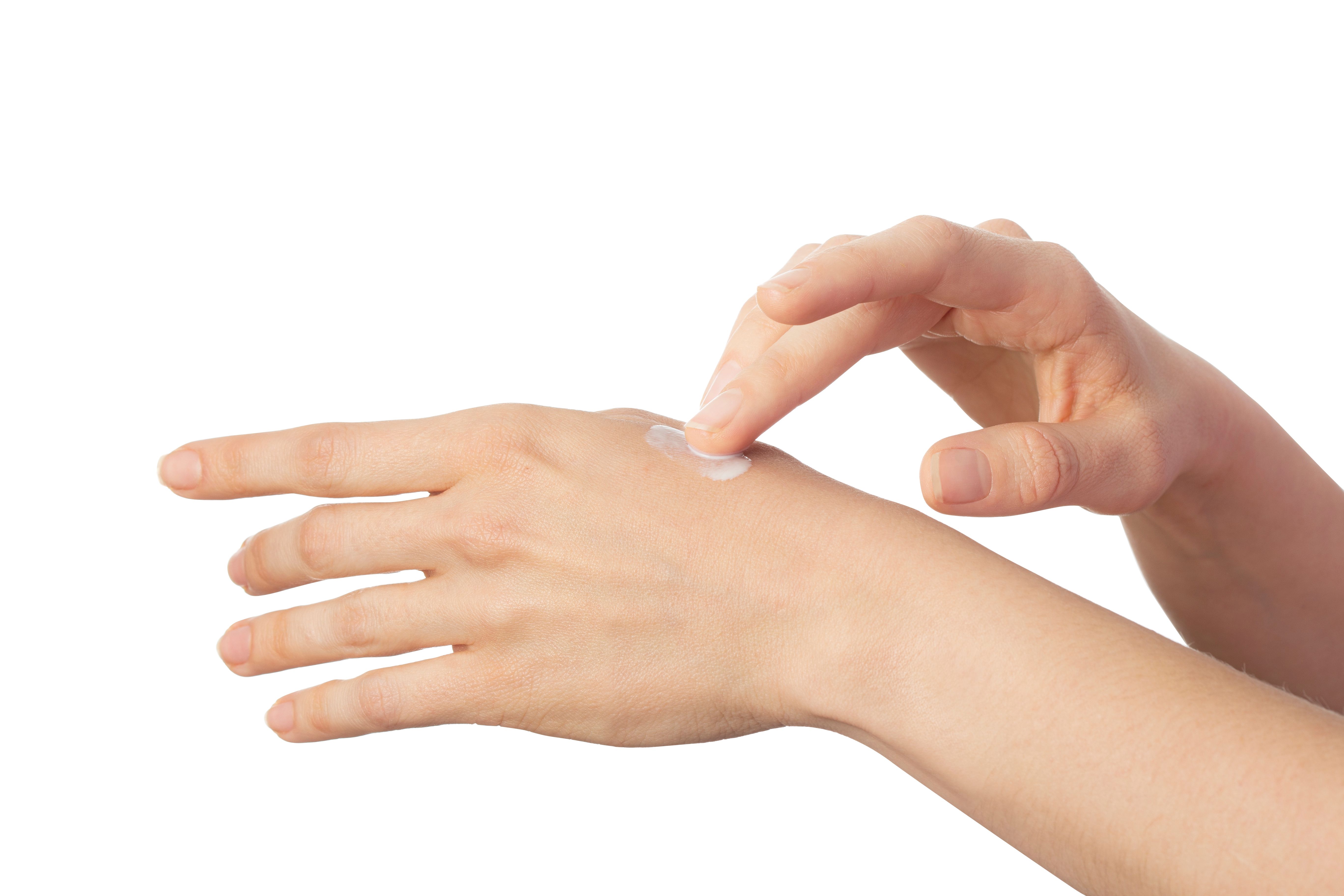 Mano che stende la crema sulla pelle. Crema sulla pelle.