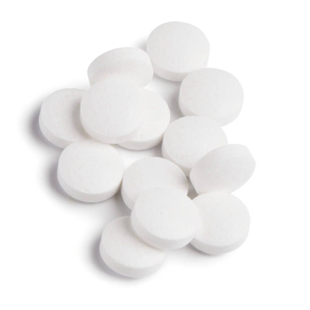 Mucchio di compresse bianche e rotonde. Nessun imballaggio visibile.