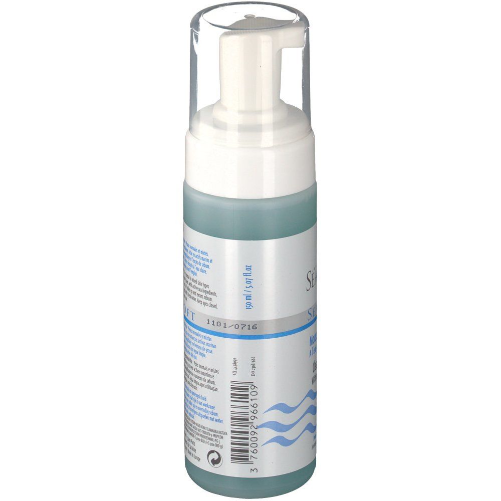 Flacone di mousse detergente con erogatore bianco e tappo trasparente. Liquido blu visibile. Codice a barre e testo sull'etichetta.