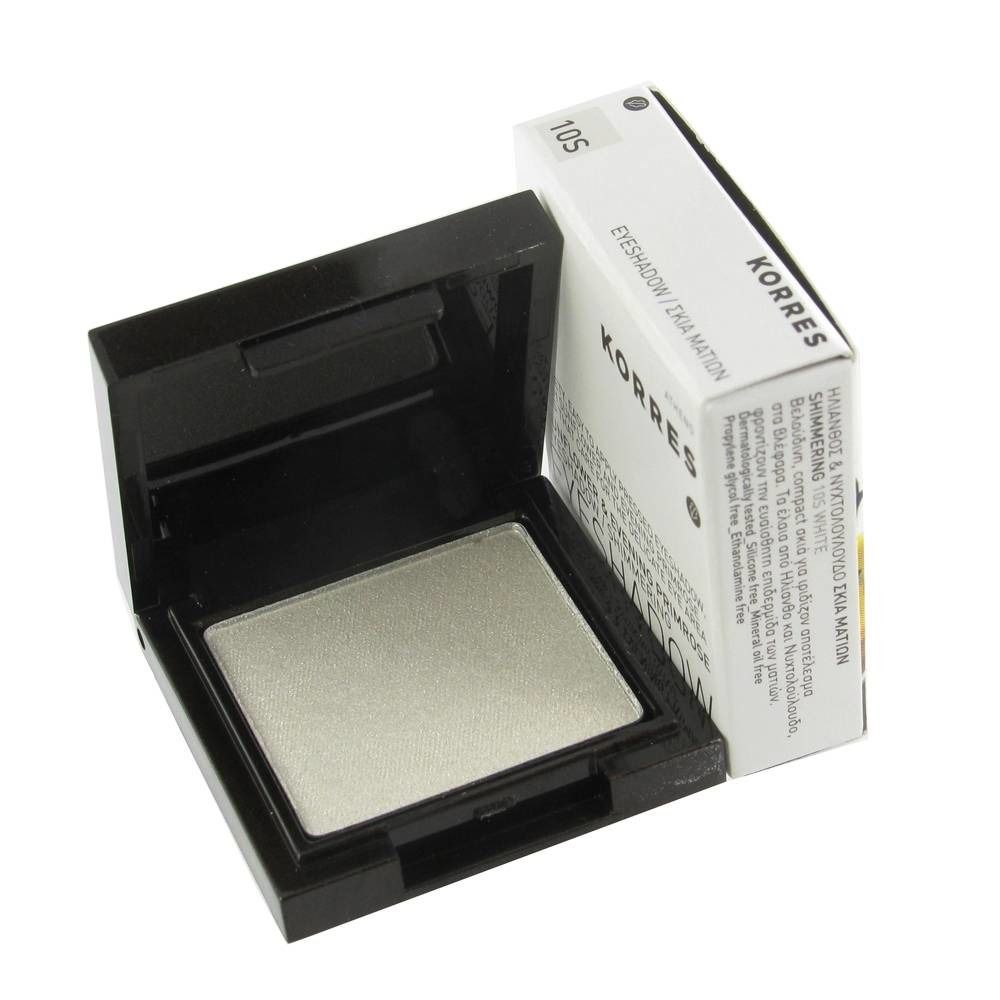 Contenitore per ombretto aperto con ombretto bianco. Accanto, una confezione bianca con testo. Contenitore nero.