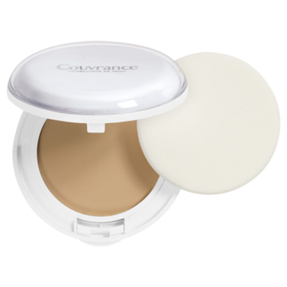 Make-up compatto in custodia bianca aperta. Contiene make-up e spugnetta. Coperchio con scritta.