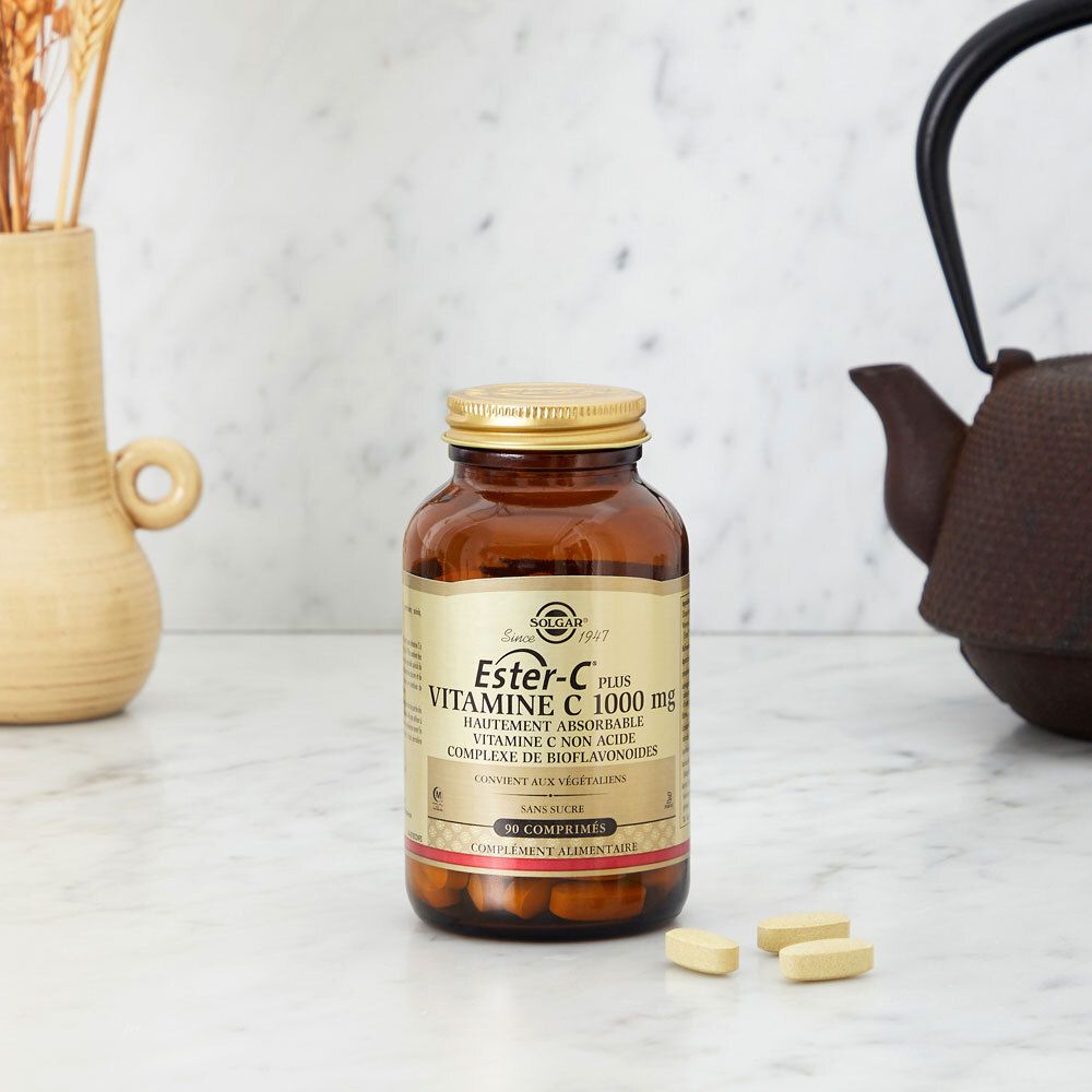 Flacone di vetro con compresse su un tavolo. Decorazioni sullo sfondo. Nome del prodotto e logo visibili.