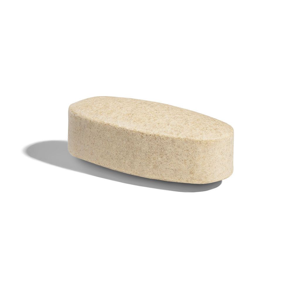 Singola compressa oblunga. Colore beige chiaro. Bordi arrotondati. Poggia su sfondo bianco.