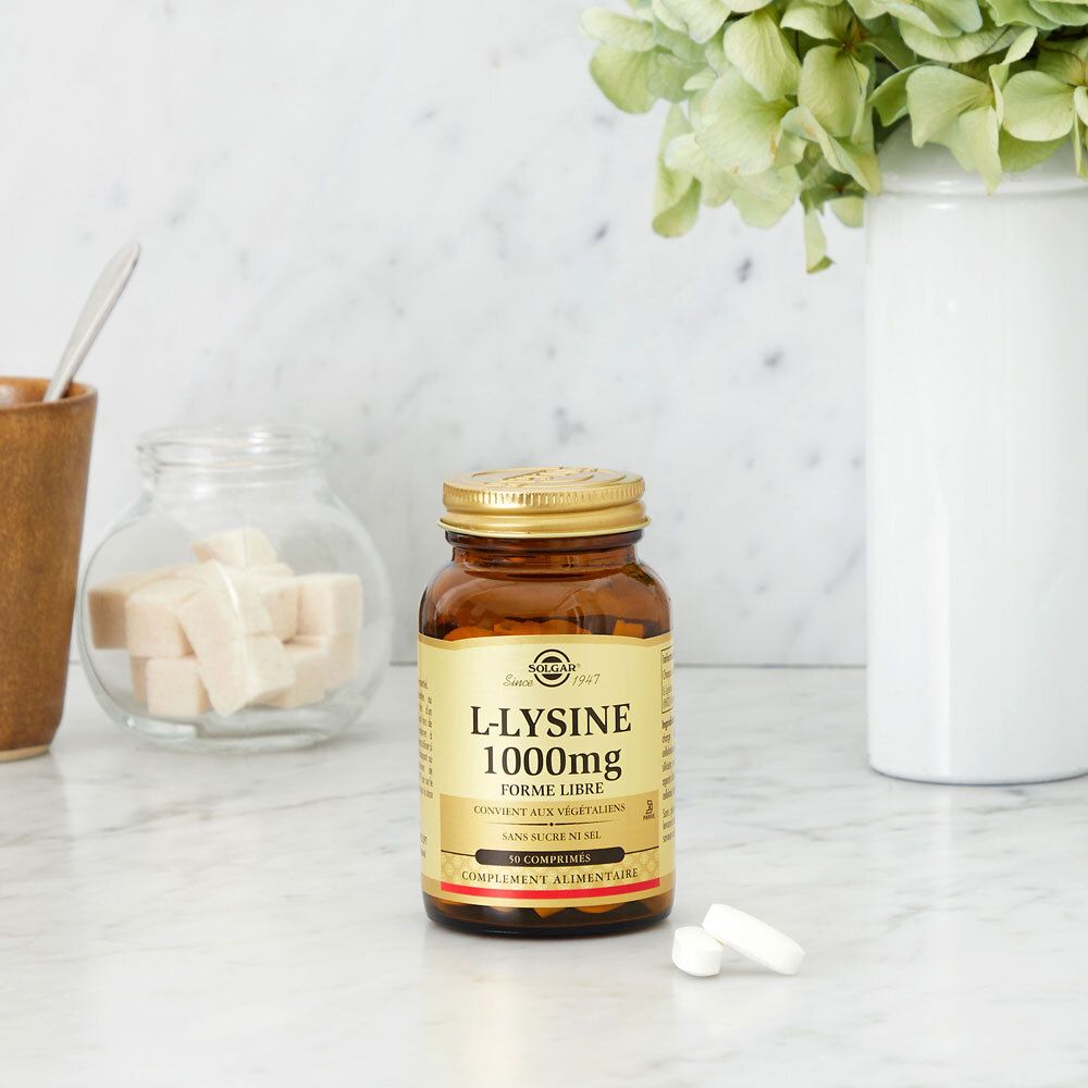 Flacone marrone con tappo dorato su superficie marmorea. Due compresse accanto.