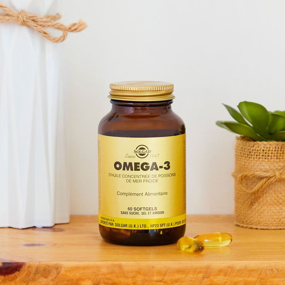 Flacone marrone con tappo dorato. Scritta Omega-3. Accanto a decorazioni.