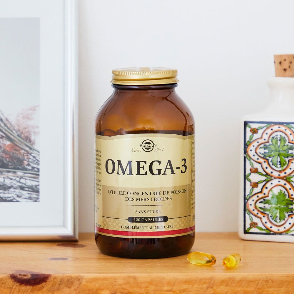 Flacone marrone con tappo dorato. Posizionato su una mensola, accanto a decorazioni.