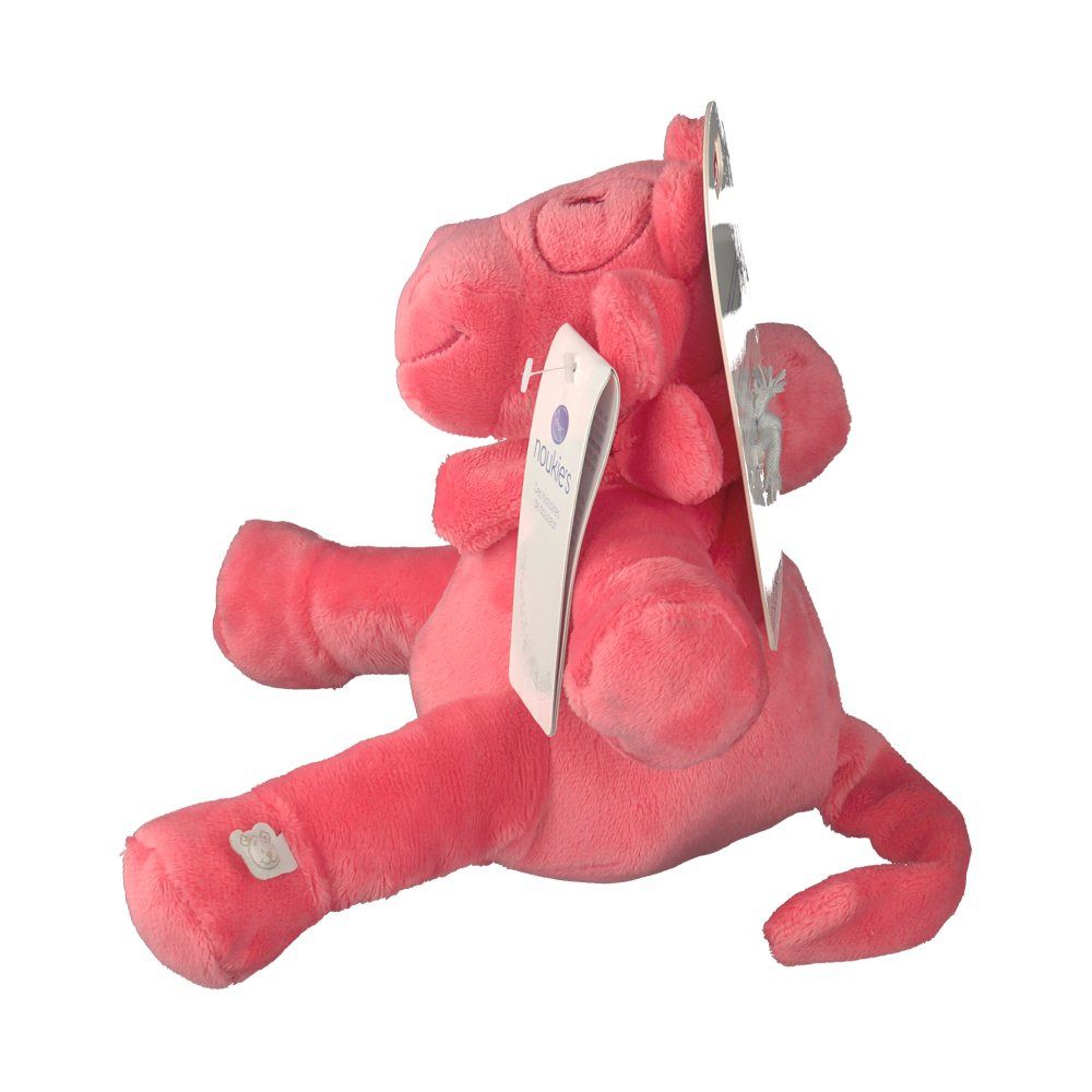 Peluche rosa a forma di mucca. Vista laterale. Etichetta con 'noukies'. Materiale morbido. Logo cucito.
