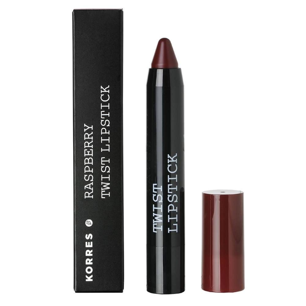Rossetto Korres Himbeere Twist. Stick di rossetto rosso scuro con astuccio nero e cappuccio separato. Confezione nera con testo.