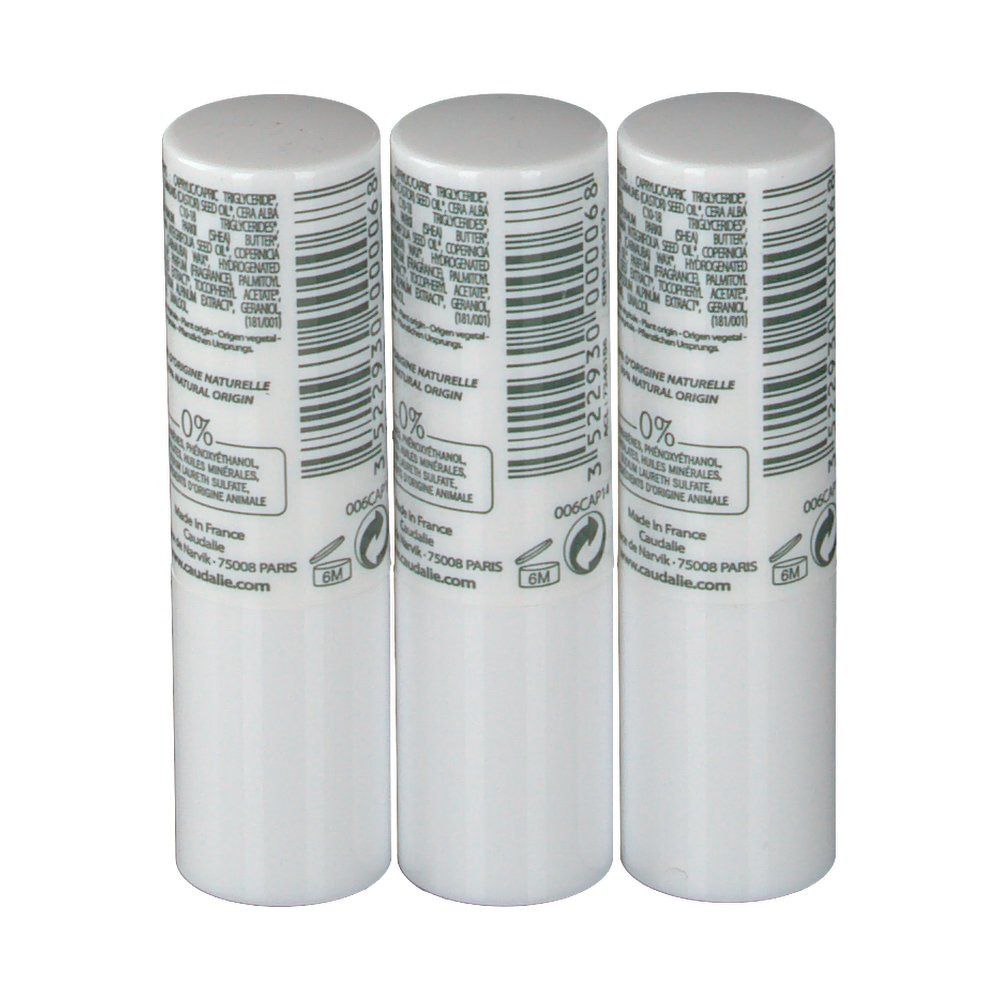 Tre stick labbra bianchi con codice a barre e informazioni. Scritta: Caudalie. Indicazione 0%. Fabbricato in Francia.
