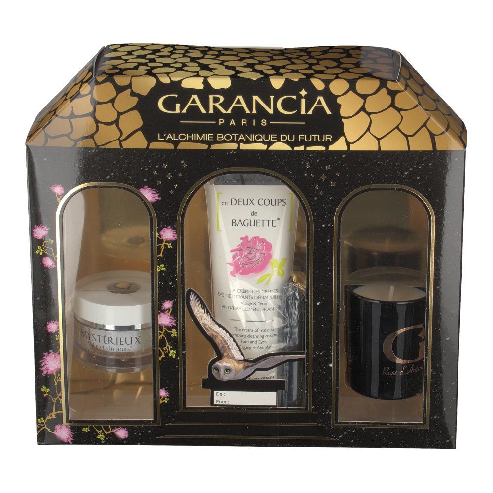Confezione regalo nera e oro con tre prodotti visibili: crema, tubo e candela. Design a finestre.