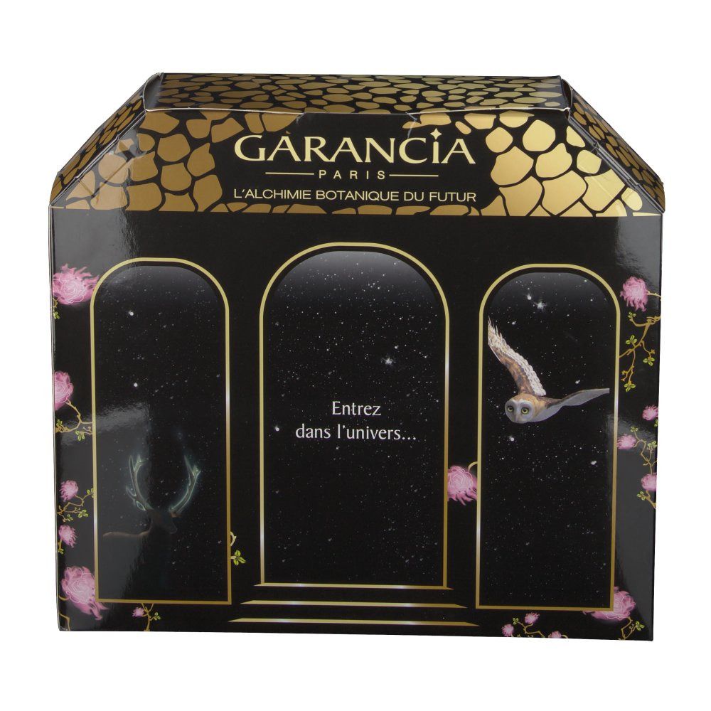 Confezione regalo con design a finestre. Imballaggio nero con accenti dorati. Testo: "Entrez dans l'univers..."