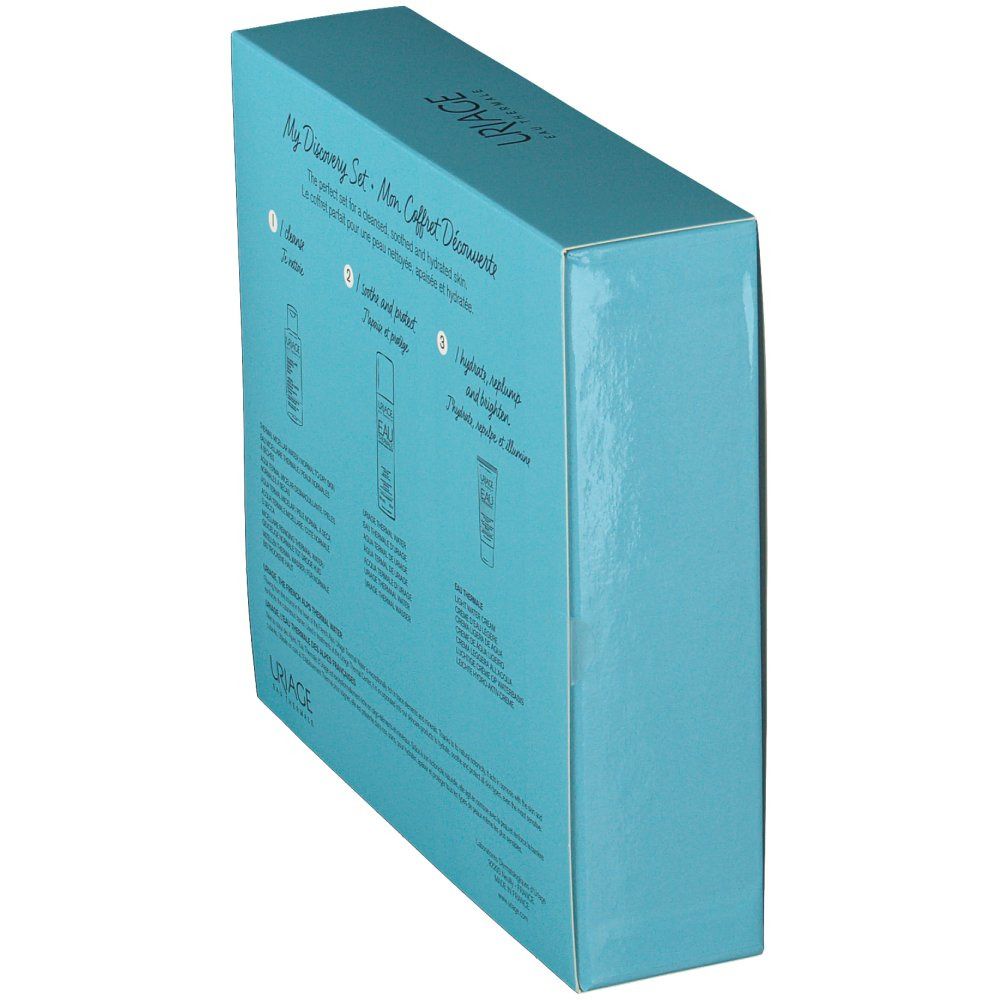 Scatola azzurra, vista laterale. Testo e immagini dei prodotti. Logo Uriage in alto. Testo multilingue.