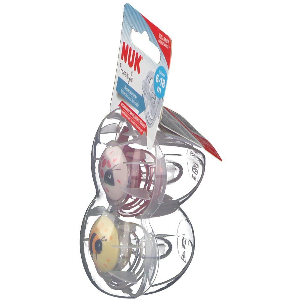 Due succhietti NUK Freestyle, 6-18 mesi, in confezione. Vista laterale. Motivi rosa e gialli.