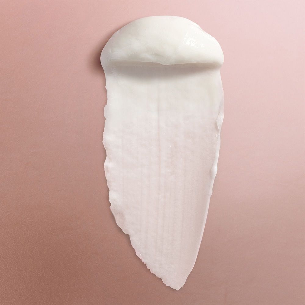 Prodotto bianco su sfondo rosa. Traccia allungata di crema.