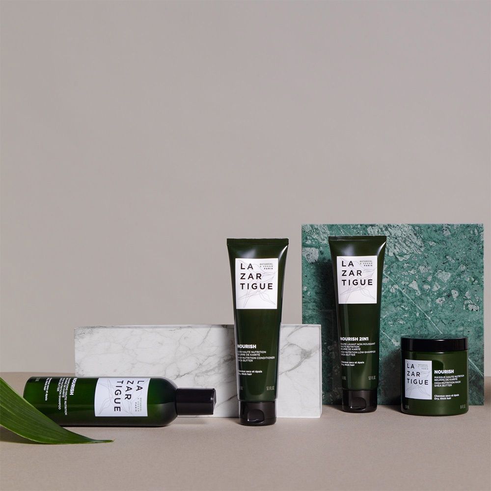 Set di prodotti LAZARTIGUE su blocchi di marmo. Bottiglia, tubo, vasetto. Confezione verde.