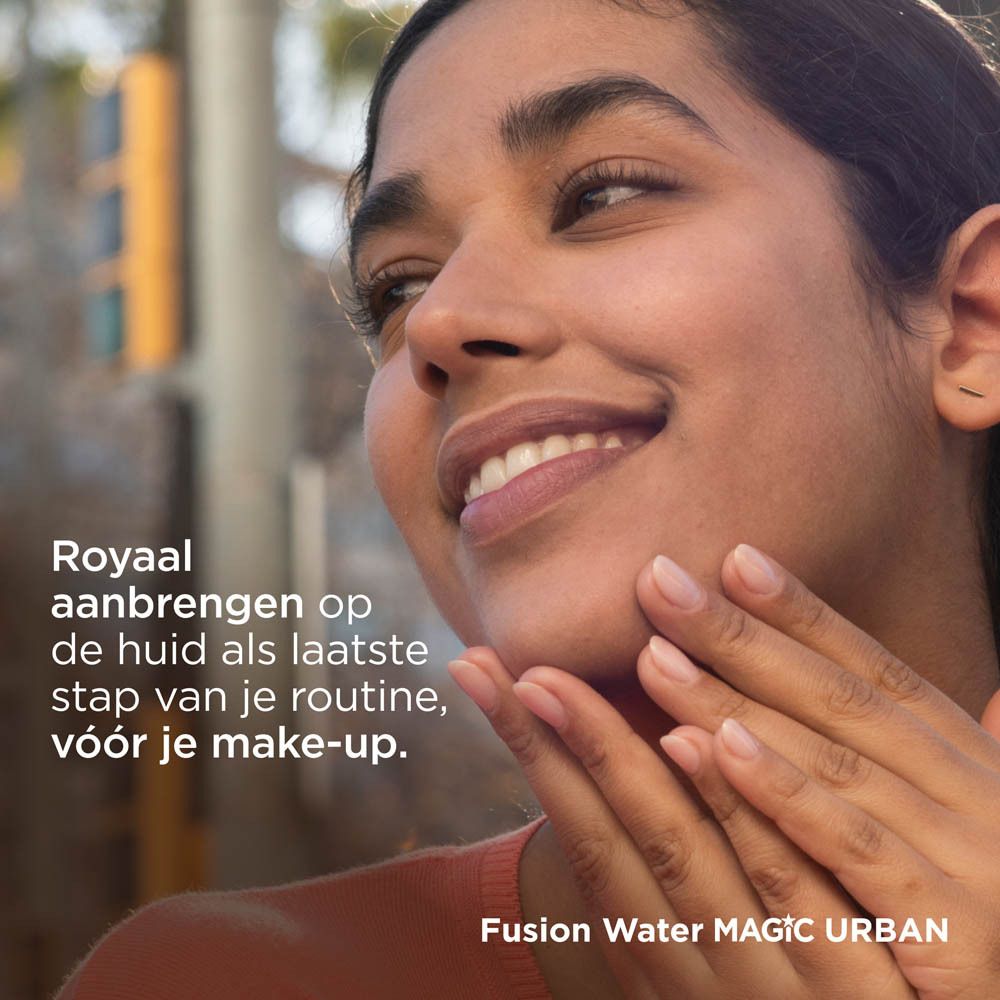 Donna applica ISDIN Fotoprotector Fusion Water Magic Urban. Viso. Sfondo: edifici.