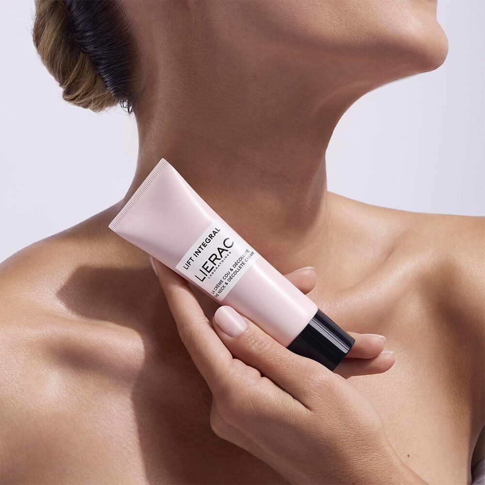 Persona che tiene in mano un tubo rosa con tappo nero. Scritta: Lift Integral, Lierac.