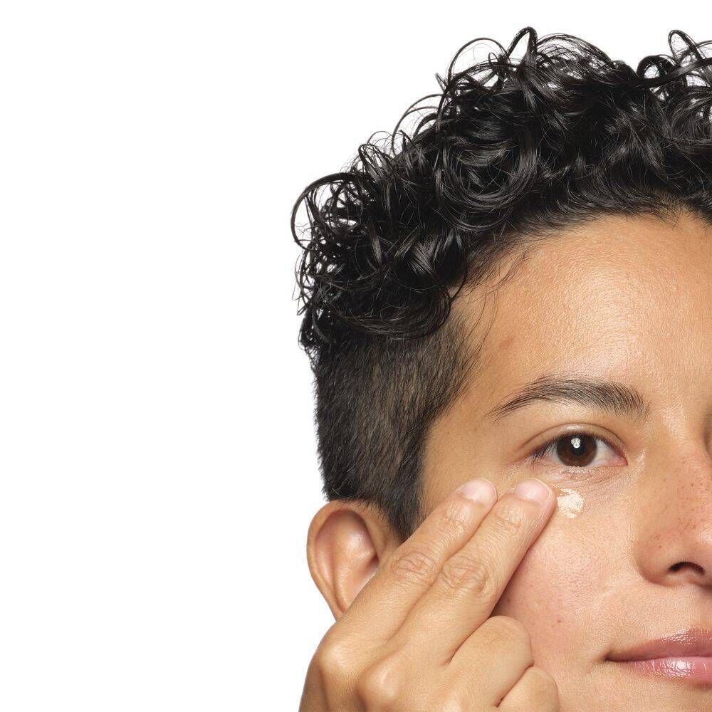 Persona che applica crema sotto l'occhio.