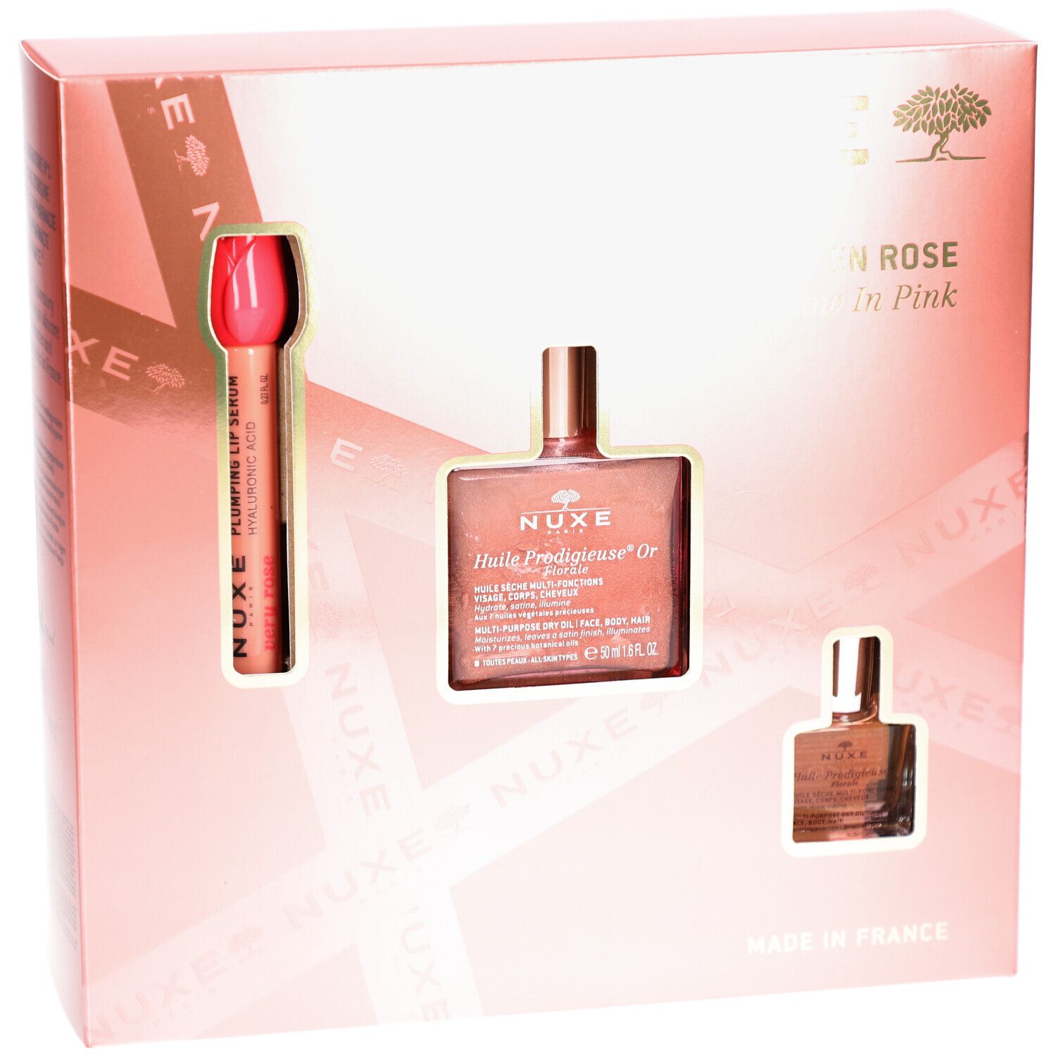 Confezione regalo rosa con tre prodotti. Visibili: rossetto, flacone d'olio e piccolo flacone. Testo: Nuxe Paris, Glow en Rose.