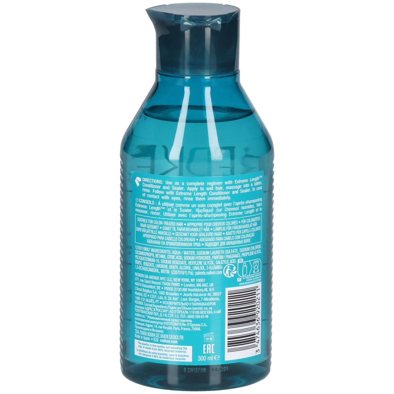 Retro di un flacone di shampoo blu trasparente. Codice a barre e testo. Contiene ingredienti e istruzioni.