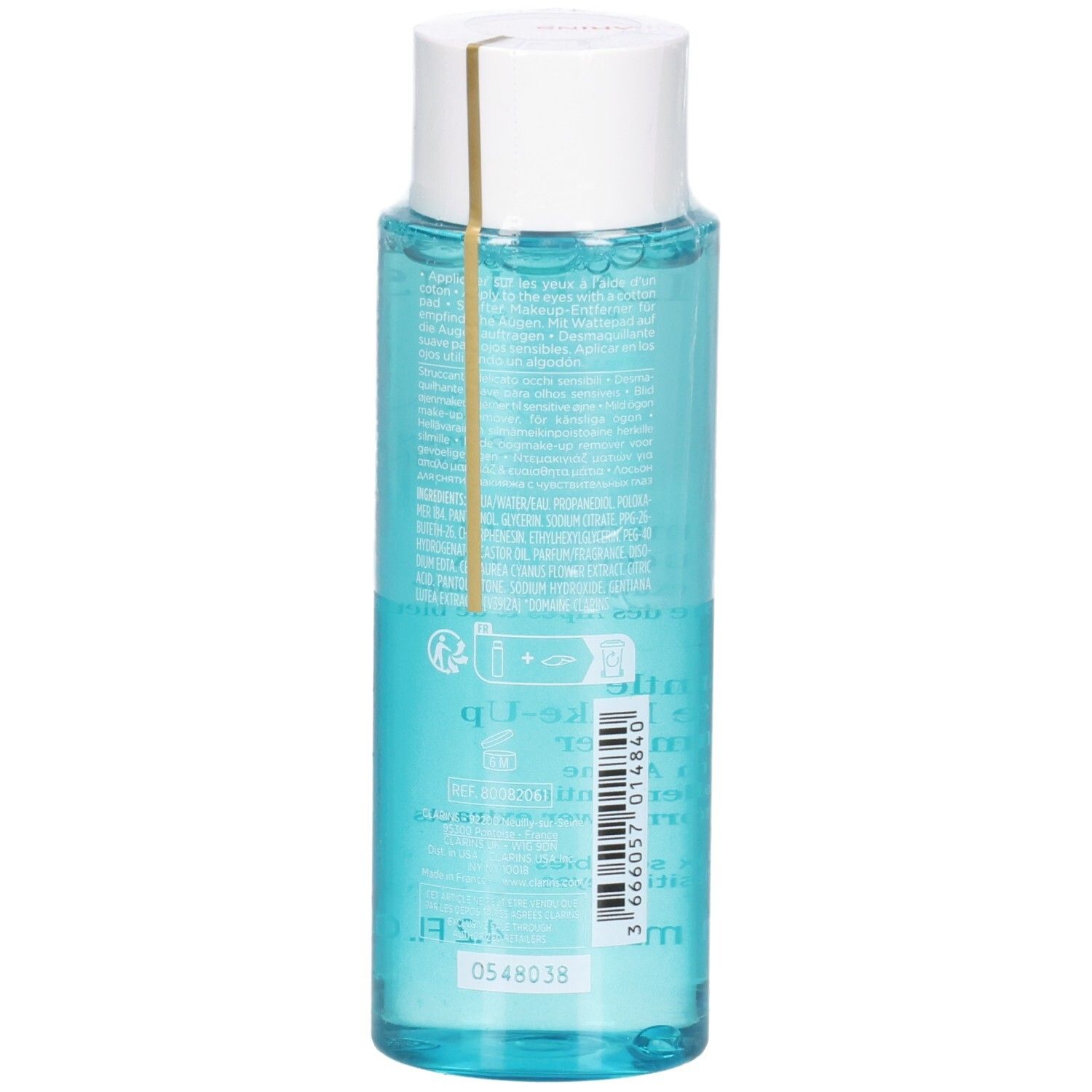 Liquido blu chiaro in una bottiglia trasparente con tappo bianco e fascia dorata. Etichetta posteriore con testo e codice a barre.