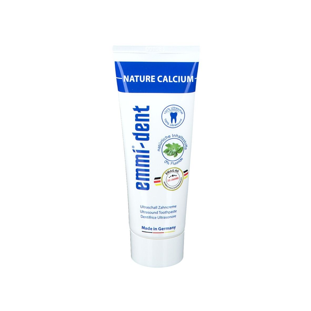 Tubo di dentifricio bianco e blu. Scritte: emmi-dent, Nature Calcium, 0% Fluoro. Sigilli e scritta 'Made in Germany'.