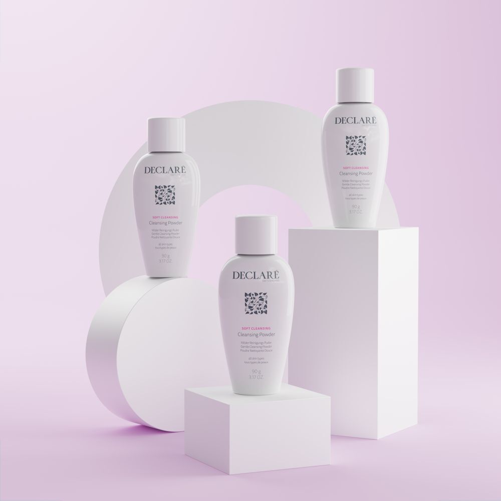 Tre DECLARÉ Soft Cleansing Poudre su piedistalli. Prodotto bianco, logo, nome, informazioni. Sfondo con forme.
