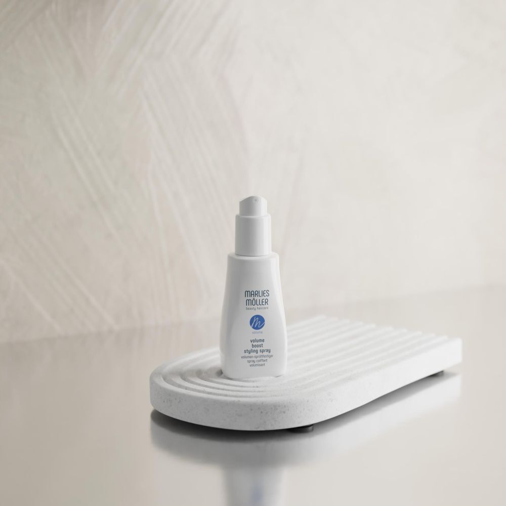 Spray bianco Marlies Möller su piedistallo bianco. Testo: Volume Boost Styling Spray.