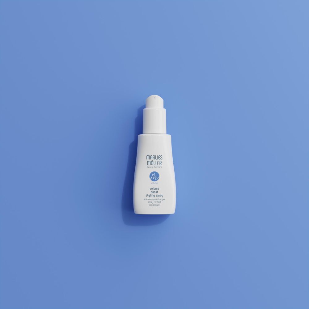 Spray bianco Marlies Möller su sfondo blu. Testo: Volume Boost Styling Spray.