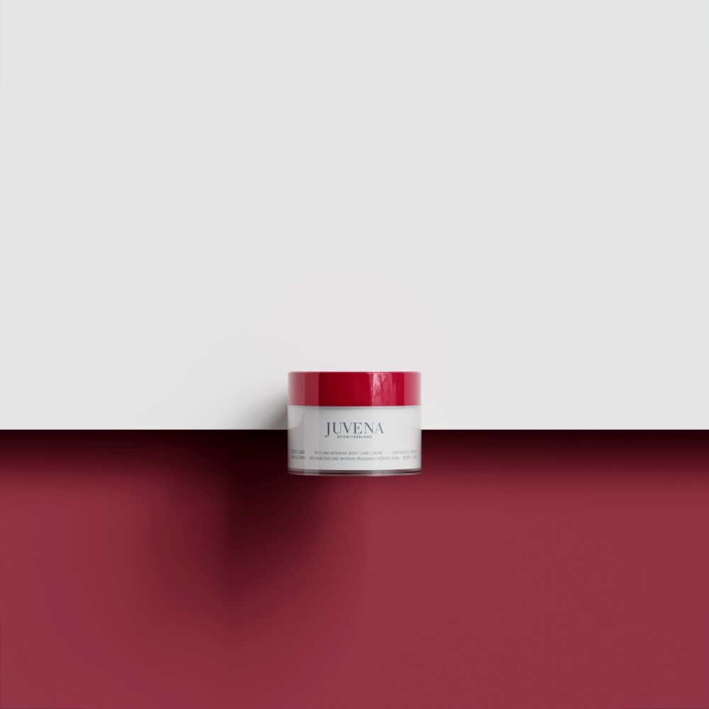 Vaso di crema con coperchio rosso su sfondo rosso. Scritta: Juvena. Nome del prodotto illeggibile.