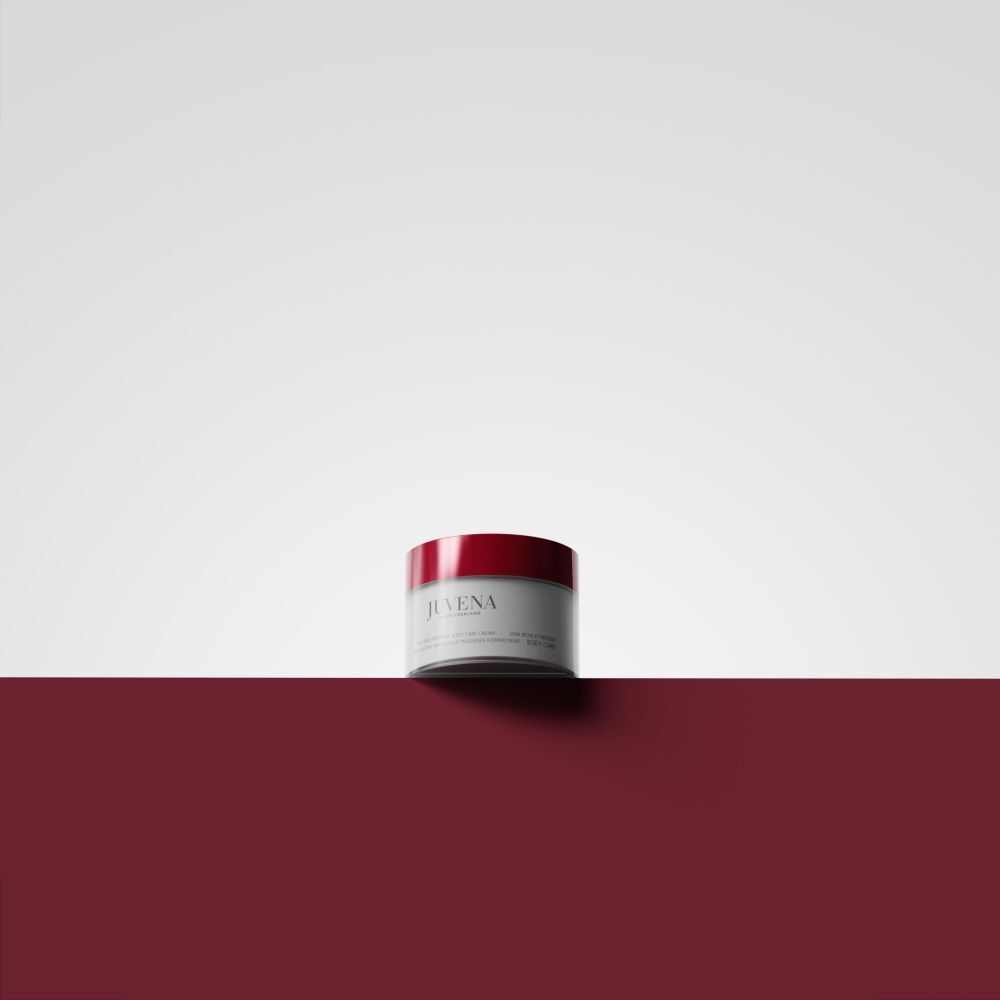 Vaso di crema con coperchio rosso su sfondo rosso. Scritta: Juvena. Nome del prodotto illeggibile.