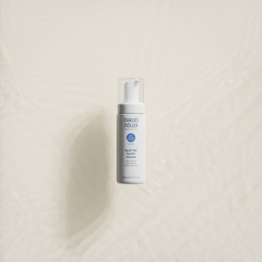 Flacone bianco con erogatore a spruzzo. Scritta: Marlies Möller, beauty haircare, Volume, Liquid Hair Keratin Mousse. Su sfondo chiaro.