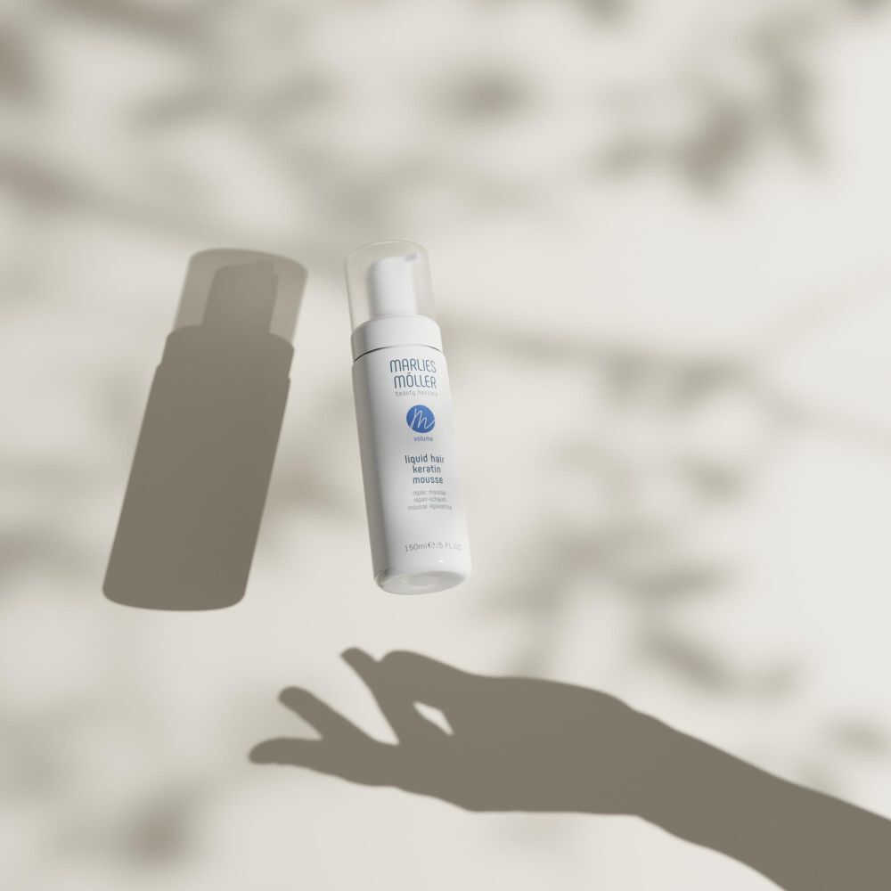 Flacone bianco con erogatore a spruzzo. Scritta: Marlies Möller, beauty haircare, Volume, Liquid Hair Keratin Mousse. Con ombre.