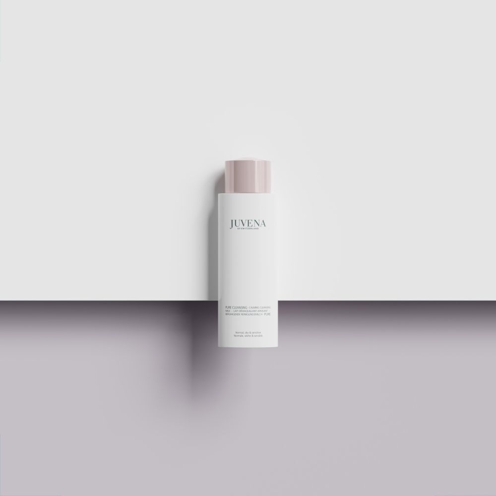 Flacone bianco con tappo rosa. Scritta: Juvena. Il prodotto è posizionato su una superficie bianca.