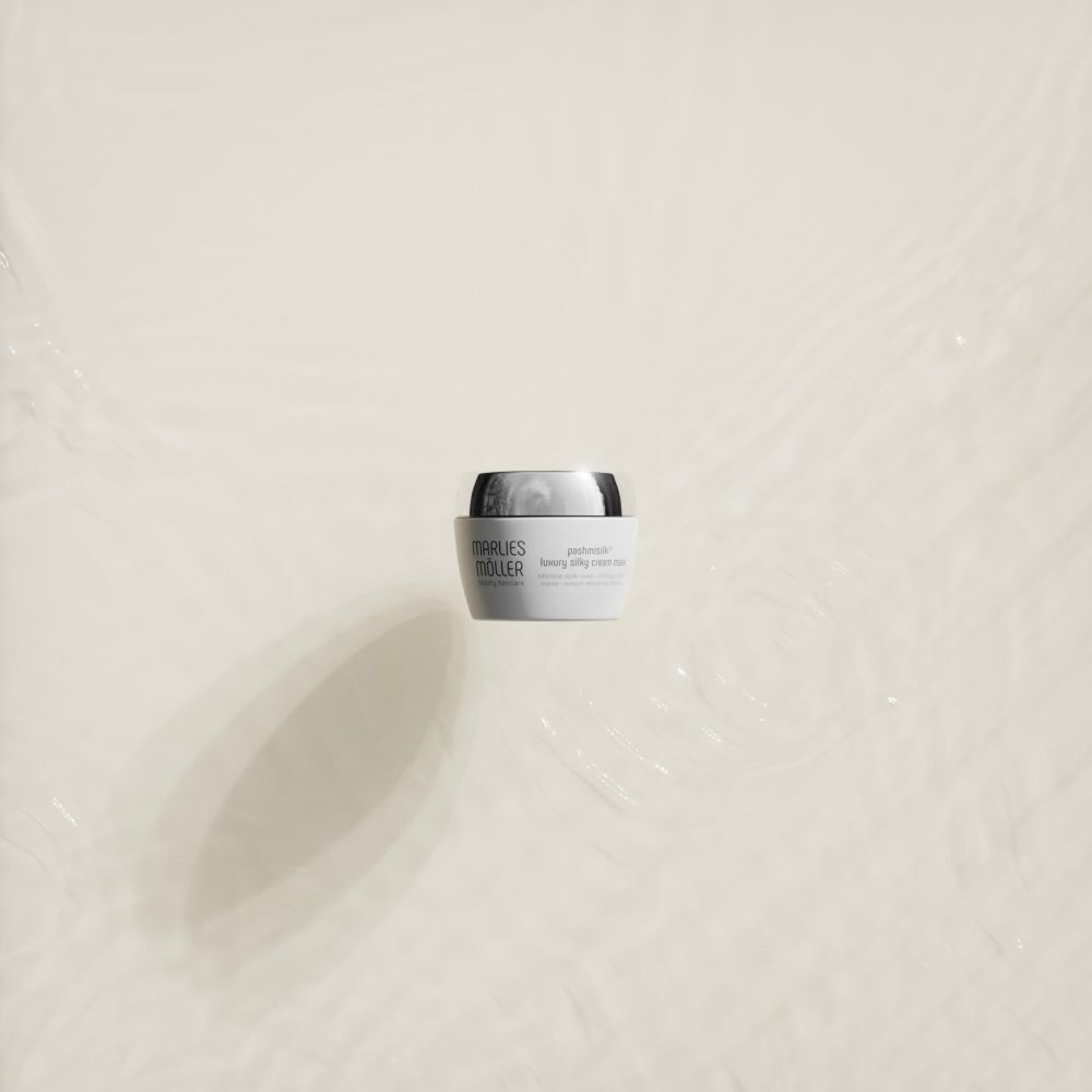 Vaso bianco con coperchio argentato nell'acqua. Nome prodotto: Marlies Möller Pashmisilk Luxury Silky Cream Mask.