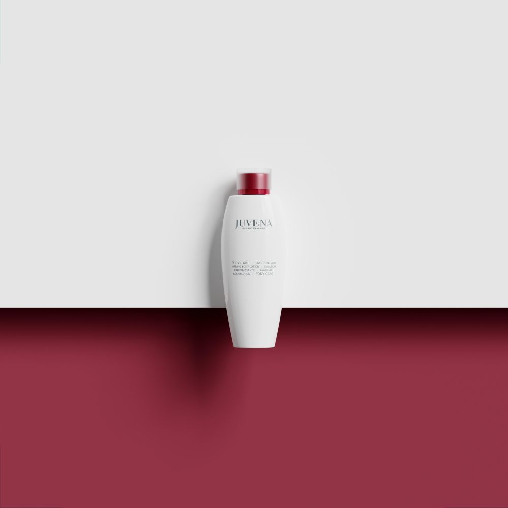 Flacone bianco con tappo rosso su sfondo bianco-rosso. Scritta: Juvena. Prodotto: Body Lotion.
