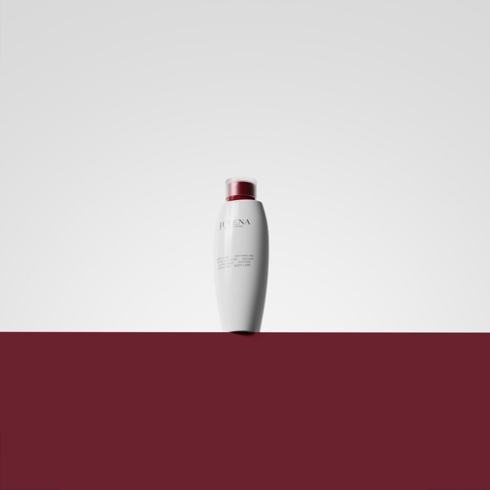 Flacone bianco con tappo rosso su sfondo bianco-rosso. Scritta: Juvena. Prodotto: Body Lotion.