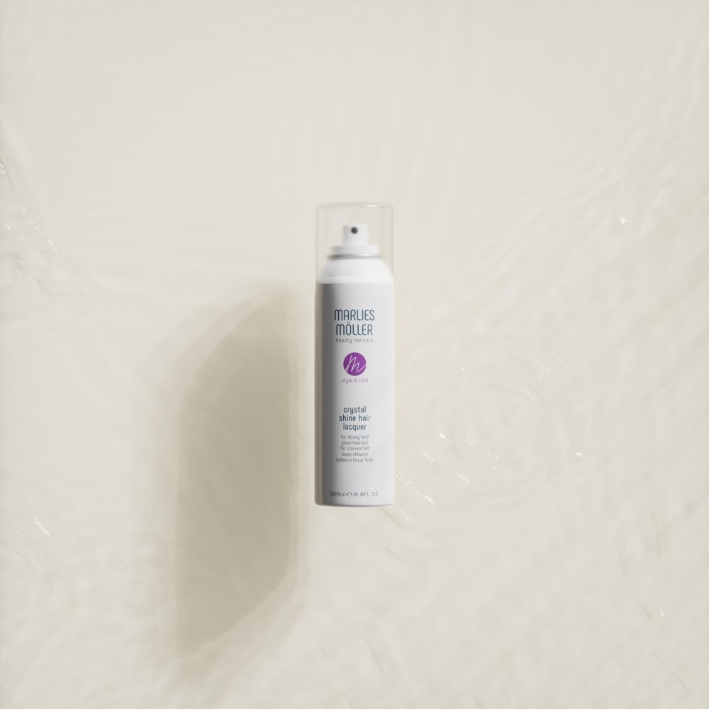 Spray per capelli bianco Marlies Möller in acqua. Scritta: Crystal Shine Hair Lacquer.