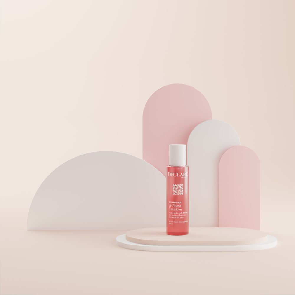 Bottiglia con liquido rosa, tappo bianco. Testo: DECLARE, EYE CONTOUR, Bi-Phase Sensitive. Su piedistallo.
