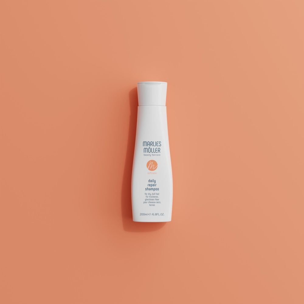 Flacone di shampoo bianco su sfondo arancione. Scritta: Marlies Müller, daily repair shampoo. 200ml/6.8FL.OZ.