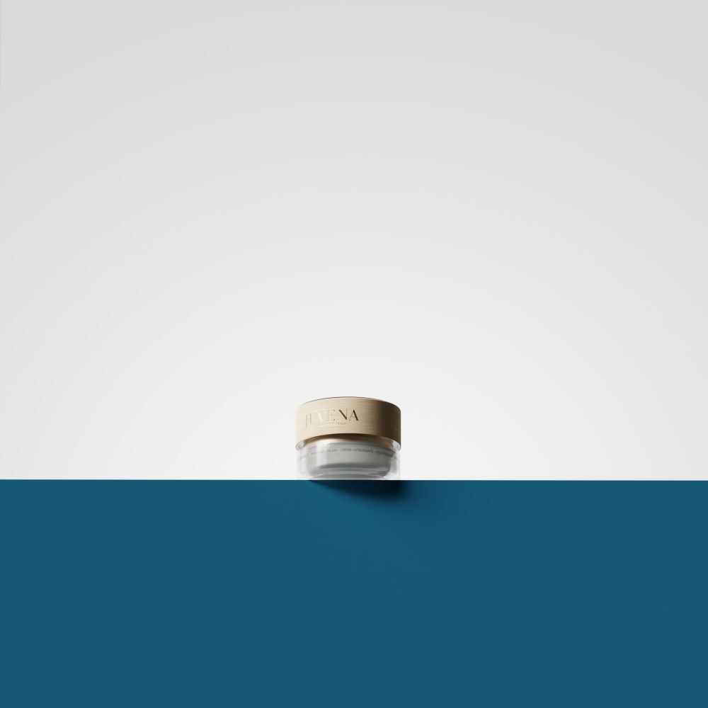 Vasetto di crema con coperchio dorato. Su sfondo bianco e blu.