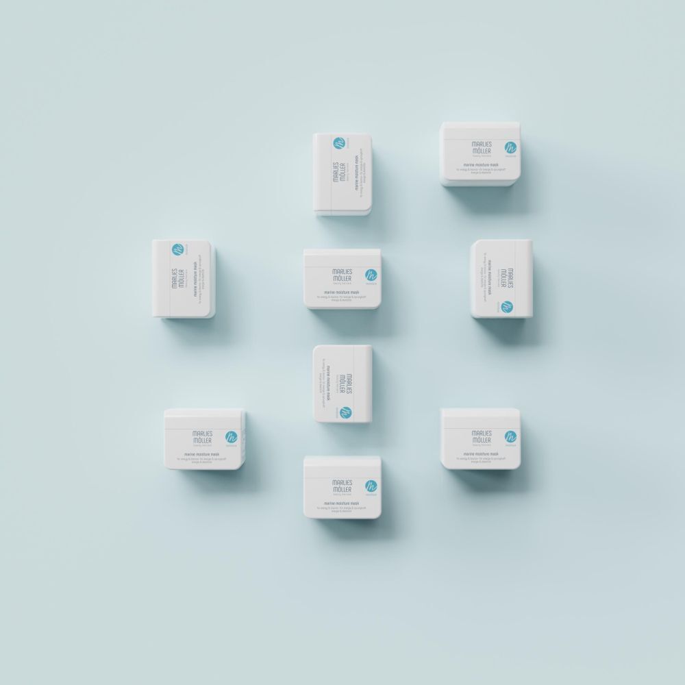 Diversi vasi bianchi su sfondo blu. Marlies Möller Marine Moisture Mask.