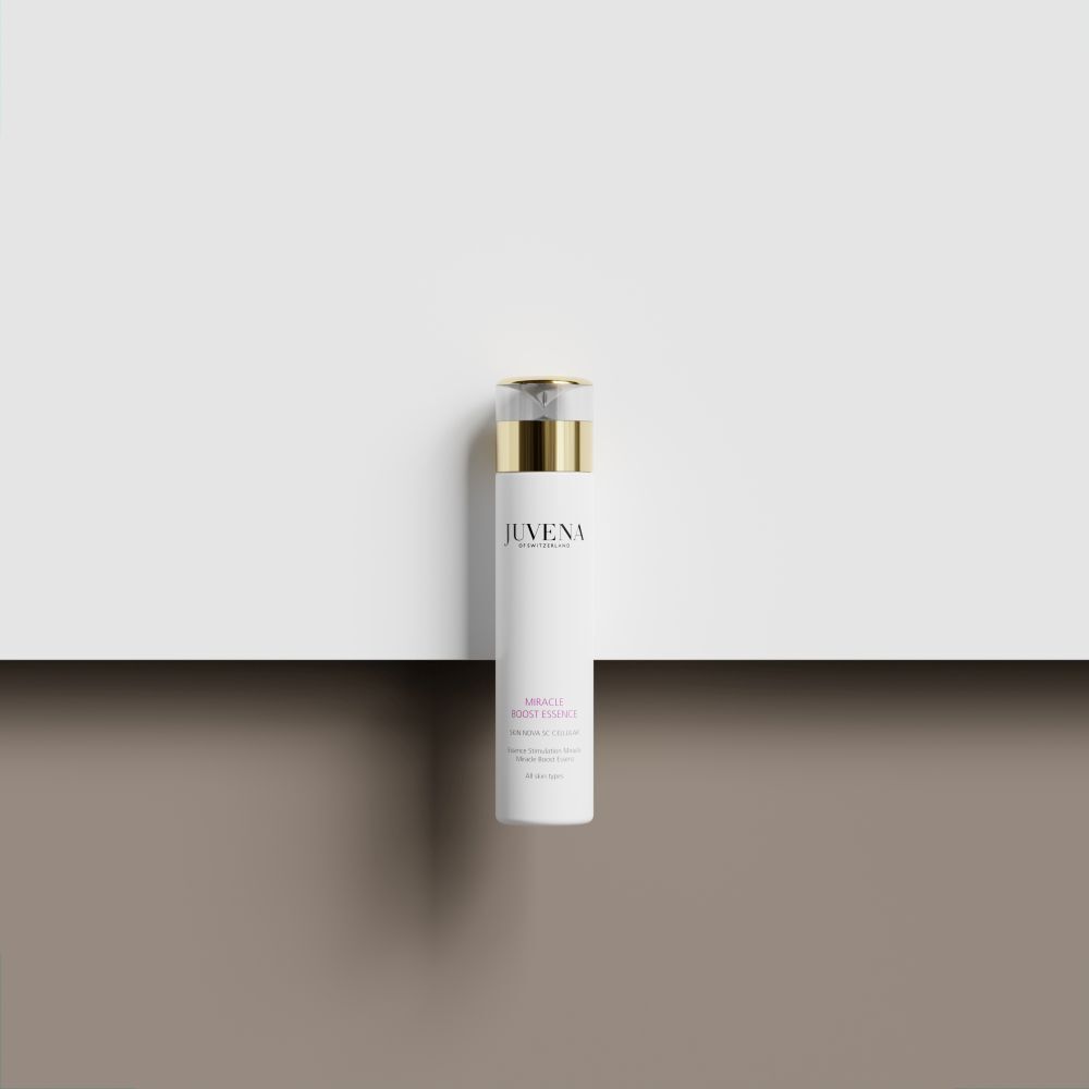 Flacone bianco con tappo dorato. Juvena Miracle Boost Essence. Su sfondo bianco.