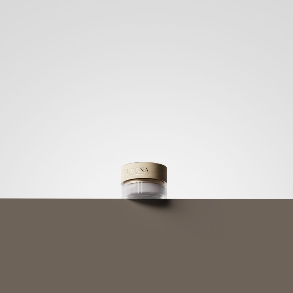 Vasetto di crema con coperchio dorato. Su superficie marrone. Sfondo bianco.