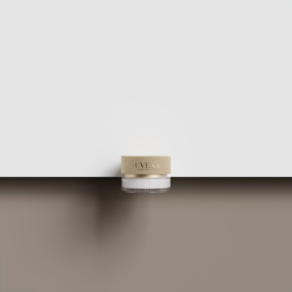 Vasetto di crema con coperchio dorato. Su superficie marrone. Sfondo bianco.