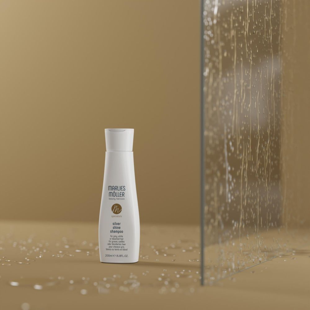 Marlies Möller Silver Shine Shampoo. Shampoo bianco davanti a una parete di vetro. Scritta: Silver Shine Shampoo. 200ml.