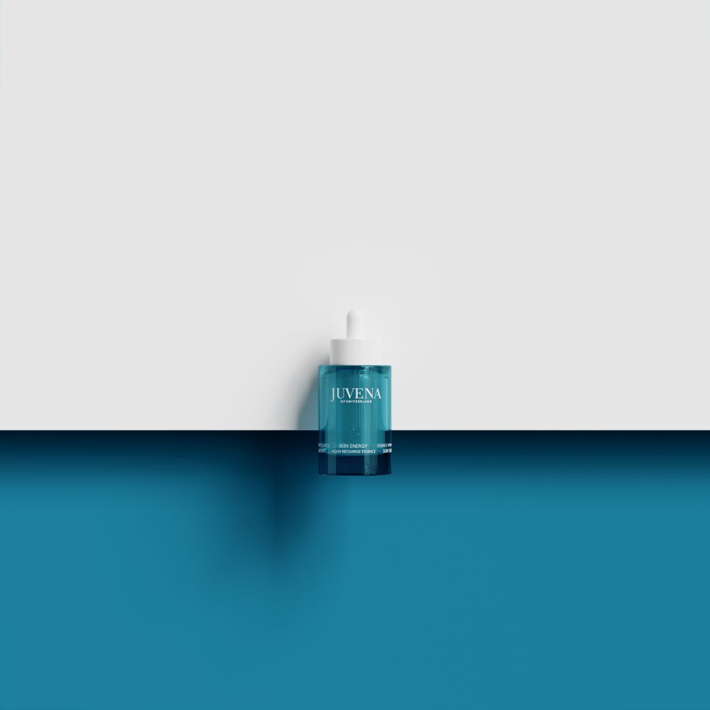 Flacone turchese con tappo bianco e pipetta. Su sfondo bianco e blu.