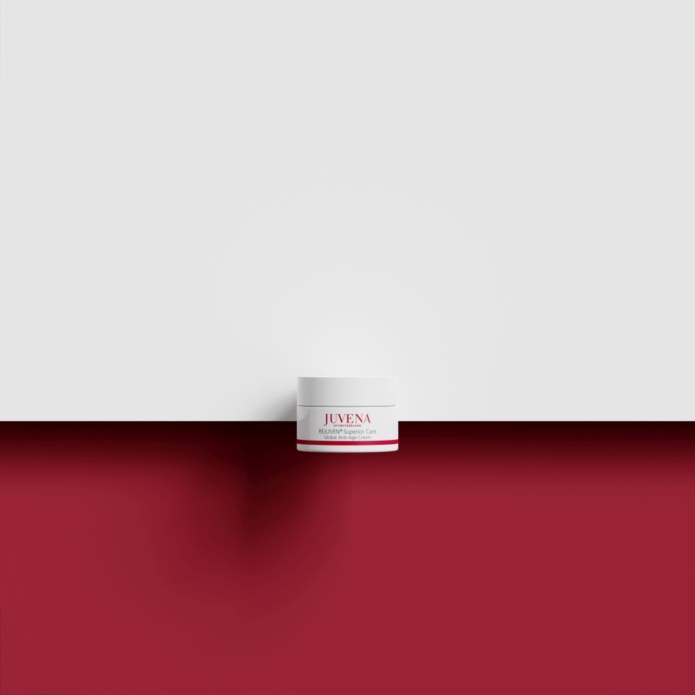 Vasetto di crema su sfondo rosso e bianco. Scritta: JUVENA, REJUVEN® Superior Care. Coperchio bianco, striscia rossa.