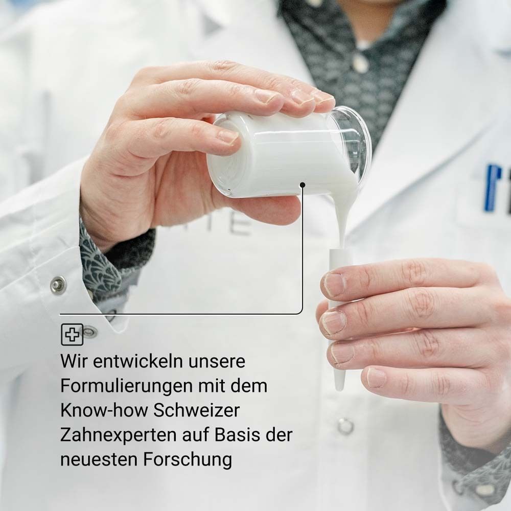 Persona che versa liquido in un contenitore. Testo: Sviluppiamo le nostre formulazioni con il know-how degli esperti dentali svizzeri.
